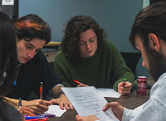 澳门新普京注册 film and production students working on a script